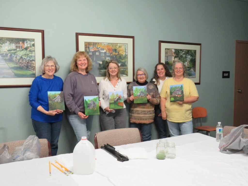 The Gallery at New Bethlehem Town Center with people holding paintings