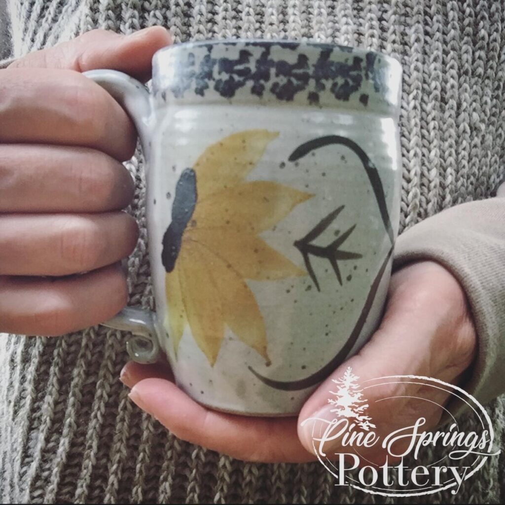 Two hands holding Pine Springs Pottery