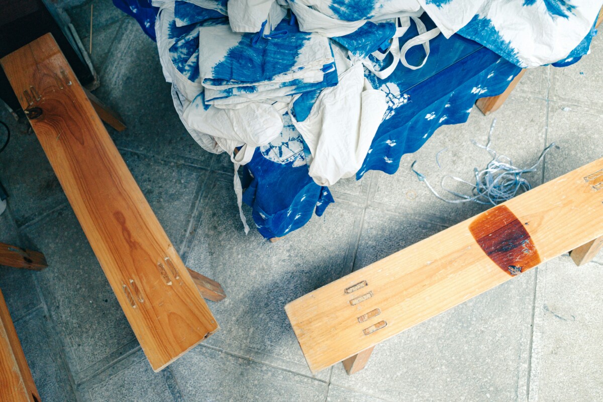 Indigo shibori workshop with two benches around the cloth